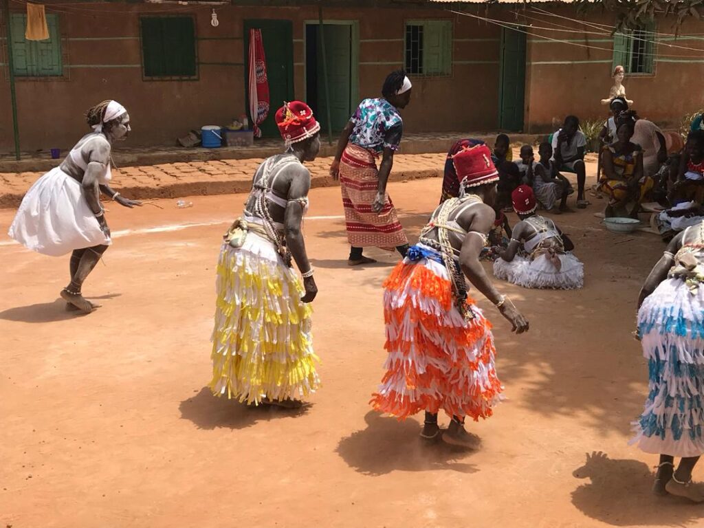 Mujeres bailando con faldas de colores en la plaza de un pueblo