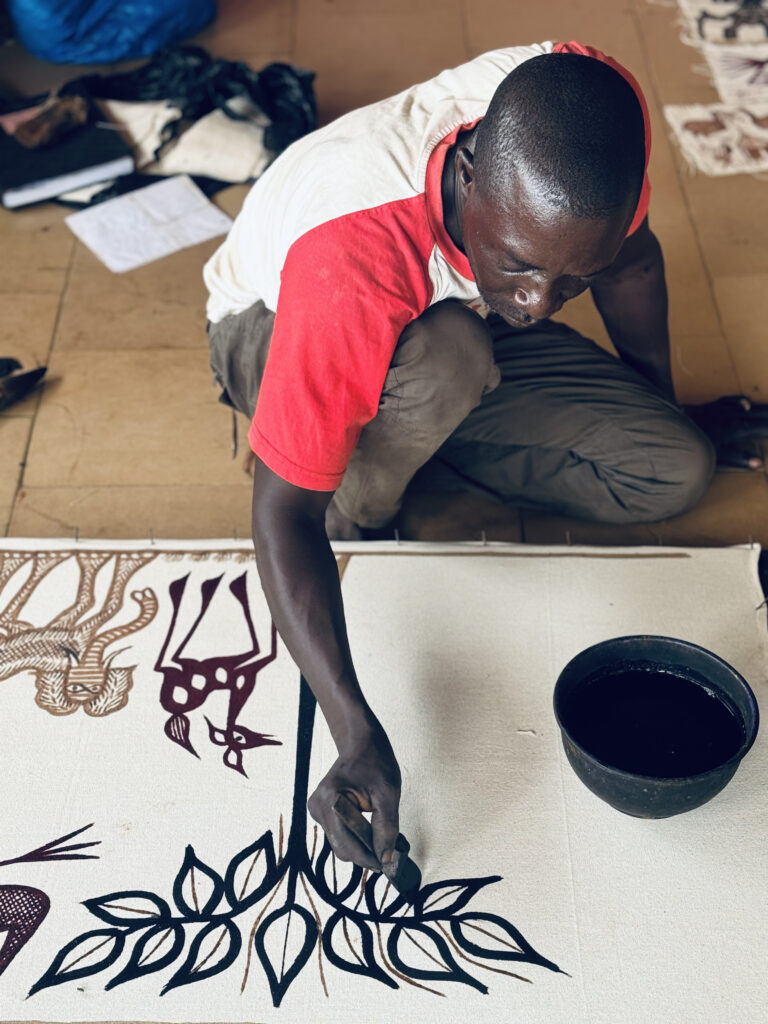Artista pintando a mano una tela de Korhogo