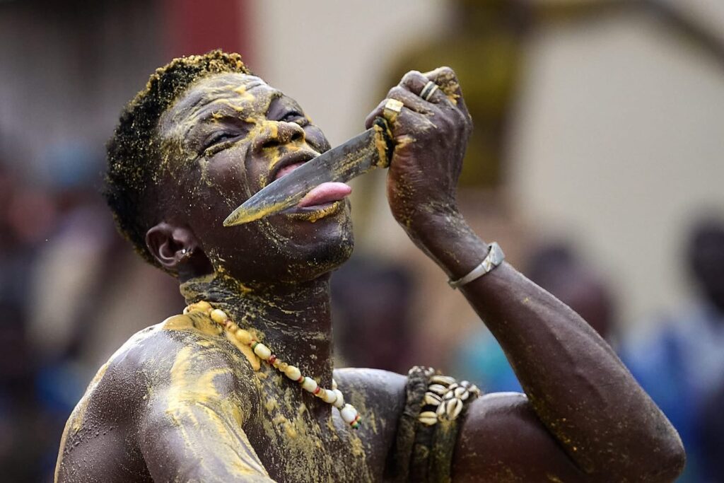 An adept of the Kokou vodun with a knife on his tongue, Benin