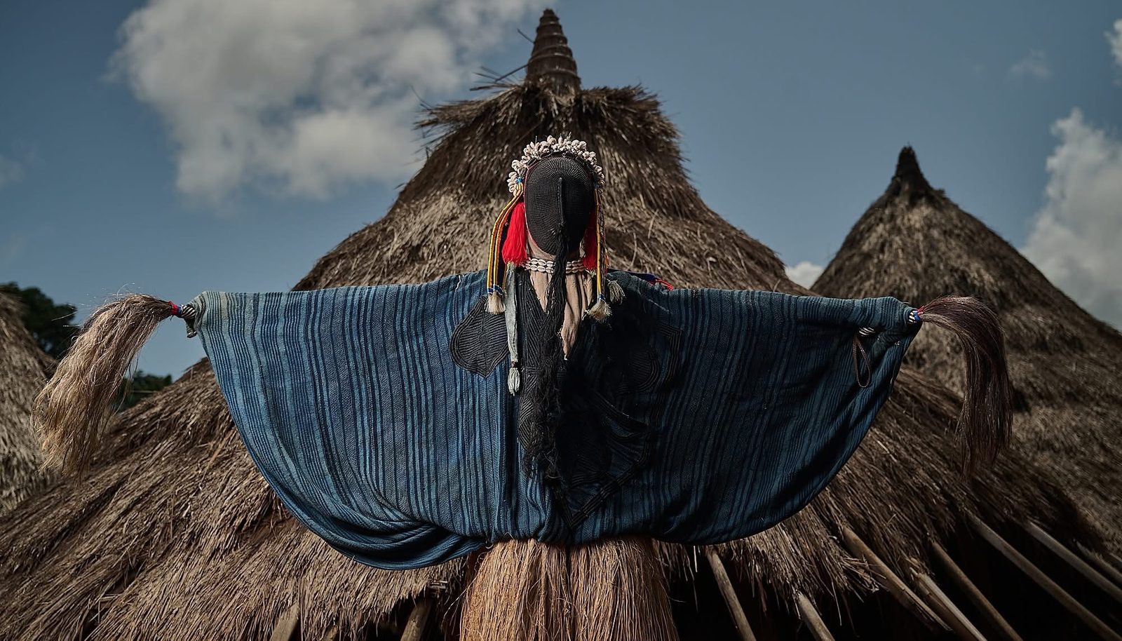Stilt dancer among the huts of a village