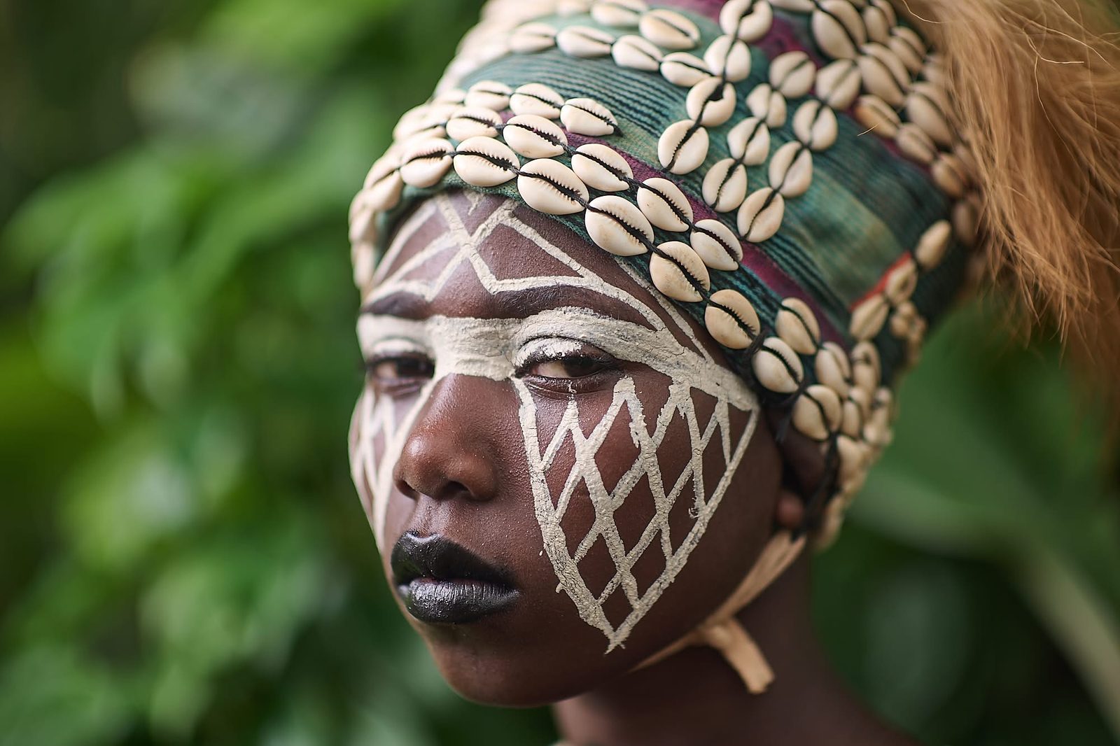 Juggler with a cowrie headdress and painted face