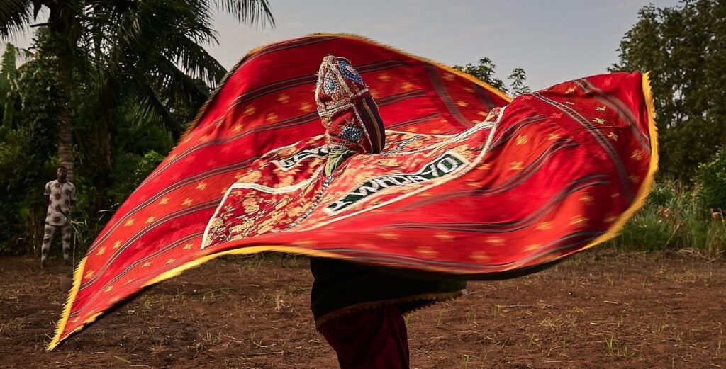 Máscara egungun girando con su tela roja, Benín