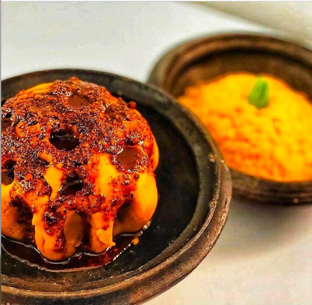 Foutou with its sauce, served in a traditional clay pot